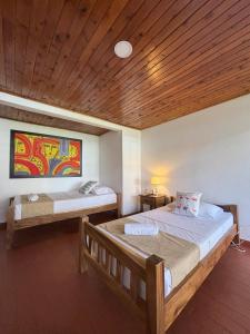 1 Schlafzimmer mit 2 Betten und Holzdecke in der Unterkunft Monte Paz Finca Hotel in Montenegro