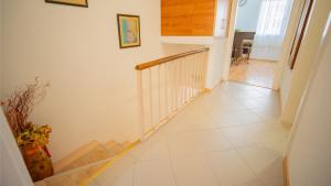 a hallway with a staircase with white tile floors at Apartmani Ana in Tivat