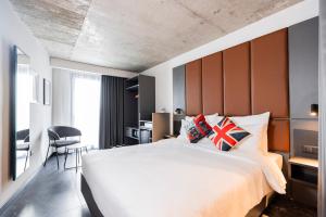 a bedroom with a large bed and a desk at The Londoner Hotel St. Julian's in St. Julianʼs