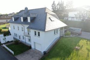 una vista aérea de una casa blanca con patio en Ferienwohnung Hochwaldblick 2, en Morbach
