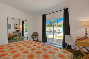 1 dormitorio con cama, escritorio y ventana en Shelby Sands, en Palm Springs