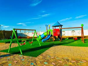 a park with a playground with a slide and swings at COMPLEXE L'OASIS in Erfoud