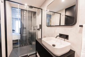 a bathroom with a sink and a shower at The Londoner Hotel St. Julian's in St. Julianʼs