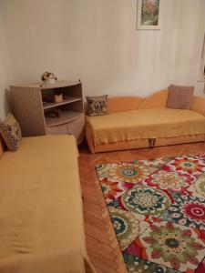 a living room with two couches and a rug at HARMÓNIA HÁZ in Makó