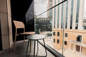 a table and two chairs on a balcony with a view at The Londoner Hotel St. Julian's in St. Julianʼs