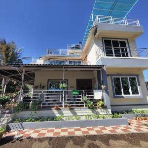 een wit huis met een balkon erop bij Kasturi Villa - A home away from home in Mandve