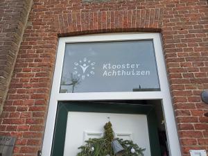 een raam in een bakstenen gebouw met een bord dat mosevelt apartmentitariaans leest bij Klooster Achthuizen in Achthuizen
