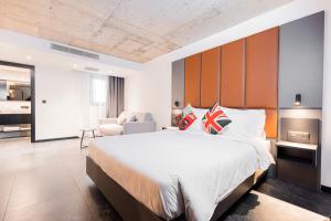 a bedroom with a large bed and a living room at The Londoner Hotel St. Julian's in St. Julianʼs