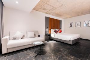 a living room with a couch and a bed at The Londoner Hotel St. Julian's in St. Julianʼs