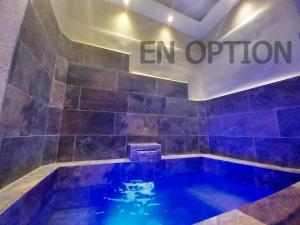 a blue swimming pool in a room with an opinion sign at L'essens in Fayence