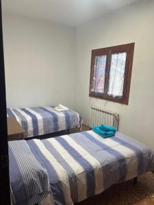 2 camas individuales en una habitación con ventana en Apartamento JUMIDOSIV, en Aliaga