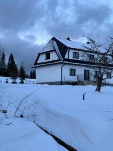 Lipnica WielkaOrawska Knieja 2.0的一座白色的房子，门前有雪
