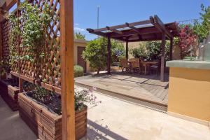 a garden with a wooden pergola and a patio at Lida Garden Studio in Anavyssos