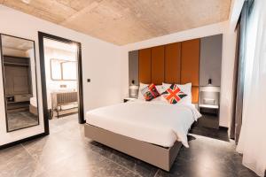 a bedroom with a large bed and a large mirror at The Londoner Hotel St. Julian's in St. Julianʼs