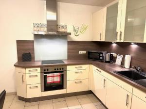 a kitchen with white cabinets and a stove top oven at Ferienwohnung in Oberahr in Oberahr