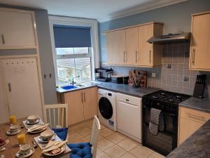 a kitchen with a table with dishes on it at 39 Queens Road in Swanage