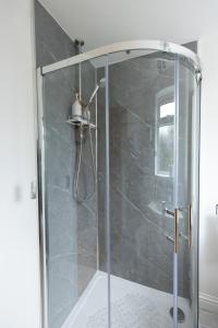 a shower with a glass door in a bathroom at Palm Trees House - Perfect for Professionals & Families - Long-Term Stay Available in St. Ives