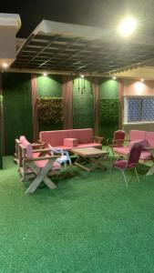 a room with tables and chairs and green carpet at استراحة زهرة الاماكن (1) in Jeddah