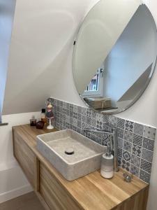 La salle de bains est pourvue d'un lavabo et d'un miroir. dans l'établissement Chambre privée Place aux oignons, à Lille