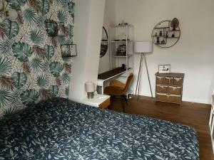 um quarto com uma cama com uma parede estampada verde em Chambre privée Place aux oignons em Lille