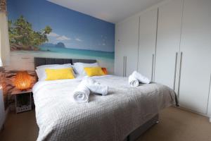 a bedroom with a bed with towels on it at Palm Trees House - Perfect for Professionals & Families - Long-Term Stay Available in St. Ives