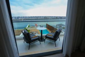 富查伊拉的住宿－Luxury Villa 5 bedrooms with sea view and free boat，阳台配有桌椅,享有风景。