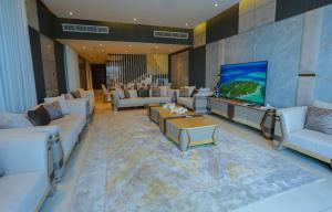 una gran sala de estar con sofás y TV de pantalla plana. en Luxury Villa 5 bedrooms with sea view and free boat en Fujairah