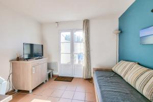 um quarto com uma cama, uma televisão e uma janela em Maison avec terrasse - résidence piscine em La Flotte