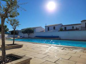 uma piscina numa villa com uma árvore em Maison avec terrasse - résidence piscine em La Flotte