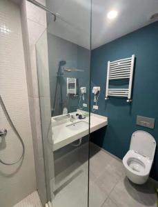 a bathroom with a toilet and a sink and a shower at New Gudauri Redco Premium Apartments in Gudauri