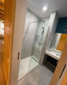 a bathroom with a glass shower and a sink at New Gudauri Redco Premium Apartments in Gudauri