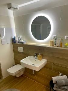 a bathroom with a sink and a toilet and a mirror at Apartmán pod Tatrami in Poprad