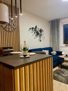a kitchen and living room with a blue couch at Apartmán pod Tatrami in Poprad