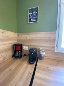una cafetera en el suelo de madera con un cartel en la pared en Au Moryllon en Lompnas