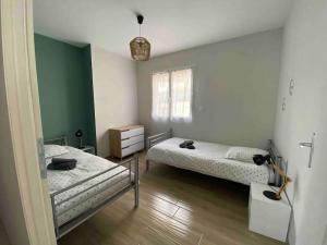 2 camas en una habitación con paredes verdes y blancas en Au Moryllon en Lompnas