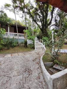 una casa con una valla blanca y un patio en Sítio Nosso Cantinho en Mogi das Cruzes