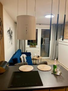 a living room with a blue couch and a table at Apartmán pod Tatrami in Poprad