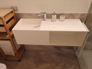 a white sink with two cups on it in a bathroom at Appartamento in centro Bergamo in Bergamo