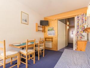 a room with a table and chairs and a bedroom at Studio Les Arcs 2000, 1 pièce, 4 personnes - FR-1-346-467 in Arc 2000