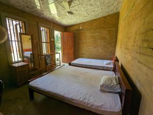 two beds in a room with two windows at P&G Hotel and Water Purification Center in Hambantota