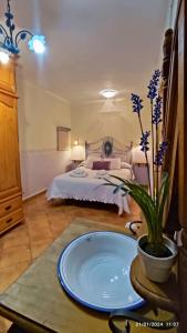 1 dormitorio con cama y mesa con maceta en Casita en la Sierra en Tragacete