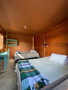 a room with two beds and a table and chairs at Casa Madera in San Marcos La Laguna