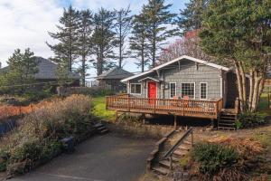 a small house with a deck with a red door at Windhover in Oceanside
