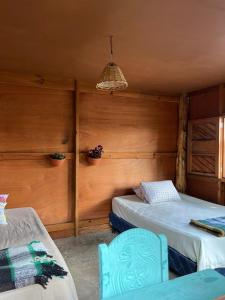 a room with two beds and a chair in it at Casa Madera in San Marcos La Laguna