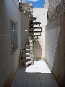 uma escada no lado de um edifício com uma janela em Casa boa e barata em Guaratuba em Guaratuba