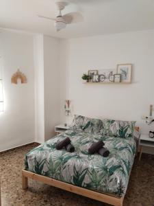 a bedroom with a bed with a leafy bedspread at La fuente in Güéjar-Sierra