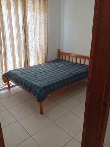 uma pequena cama num quarto com uma janela em Casa boa e barata em Guaratuba em Guaratuba