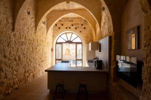 a kitchen with a counter and stools in a room at Mixel Holiday Home in Sannat