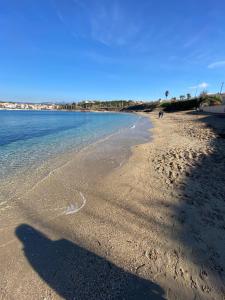 a beach with footprints in the sand and the water at Studio de charme, piscine et mer à pieds in Six-Fours-les-Plages +14 photos
