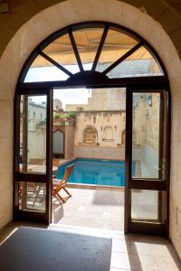 una puerta abierta a un patio con piscina en Mixel Holiday Home, en Sannat